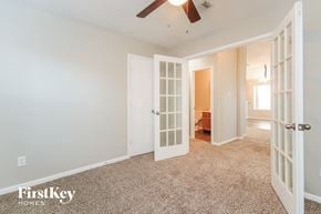 Baytown house for rent - a bedroom with a ceiling fan and a door to a closet
