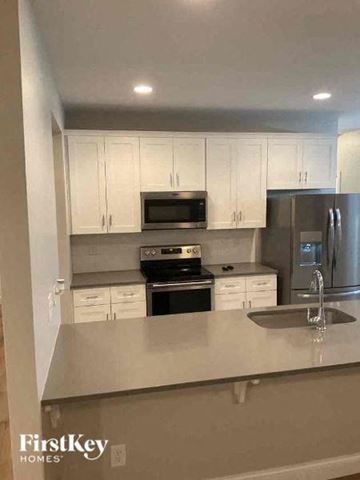 Troutman house for rent - A kitchen with white cabinets and stainless steel appliances.