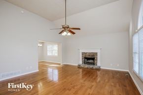 Ball Ground house for rent - an empty living room with a fireplace and a ceiling fan