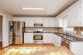 Ball Ground house for rent - a kitchen with white cabinets and stainless steel appliances