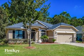 Jacksonville house for rent - A house with a well-maintained lawn and trees in the background is for sale with FirstKey Homes.