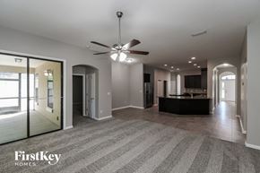 Jacksonville house for rent - A spacious living room with a ceiling fan and a striped carpet.