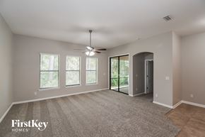 Jacksonville house for rent - A spacious room with a carpeted floor and a ceiling fan.
