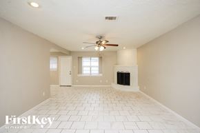 Dickinson house for rent - A spacious room with a fireplace and a ceiling fan.