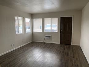 Grandview apartment for rent - A room with a brown door and a window with blinds.