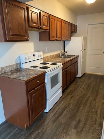 Grandview apartment for rent - A kitchen with a white stove top oven and a white refrigerator.