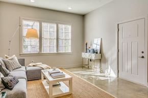 Montgomery apartment for rent - A living room with a grey couch, a coffee table, and a white door.
