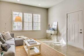 Montgomery apartment for rent - A living room with a grey couch, a coffee table, and a white door.