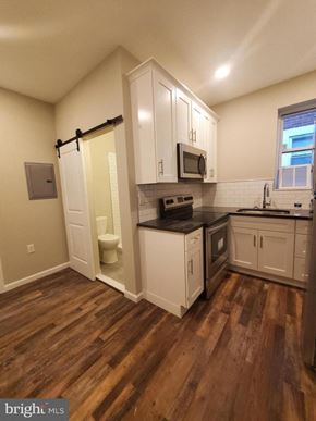 Philadelphia apartment for rent - a kitchen with white cabinets and a sink and a toilet