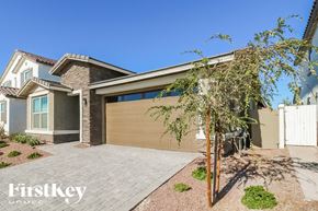 Litchfield Park house for rent - A house with a brown garage door and a tree in front.
