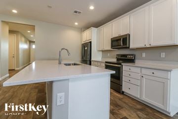 Litchfield Park house for rent - A kitchen with white cabinets and a white island with a sink.