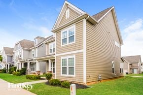 Monroe house for rent - a row of houses with tan siding and green grass