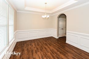 Monroe house for rent - the dining room after renovation with wood flooring and an arched door