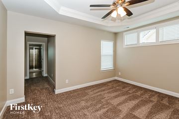 Monroe house for rent - a living room with carpet and a ceiling fan