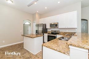 Jacksonville house for rent - a kitchen with white cabinets and granite counter tops