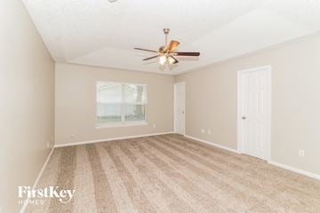 Jacksonville house for rent - a spacious living room with carpet and a ceiling fan