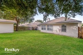 Jacksonville house for rent - a backyard with a house and a yard with grass and trees