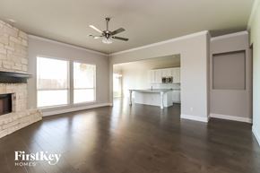Joshua house for rent - an empty living room with a fireplace and a ceiling fan