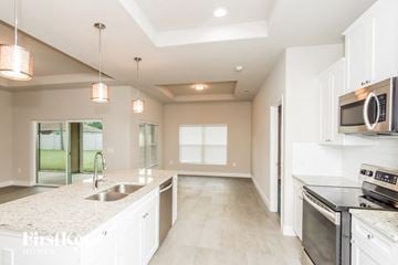 Palm Bay house for rent - A kitchen with white cabinets and a granite countertop.