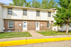 Fridley apartment for rent - the front of an apartment building with a sidewalk and grass