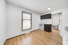Fridley apartment for rent - the living room and kitchen of an apartment with wood flooring and a window
