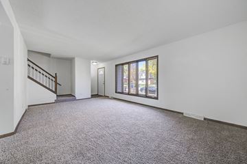St Paul apartment for rent - the living room and entryway of a house with carpet and a large window