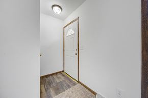 St Paul apartment for rent - the entrance to a room with a white door and a hallway with wood flooring
