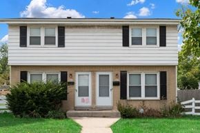 Milwaukee triplex for rent - A house with a grey front door and black shutters.