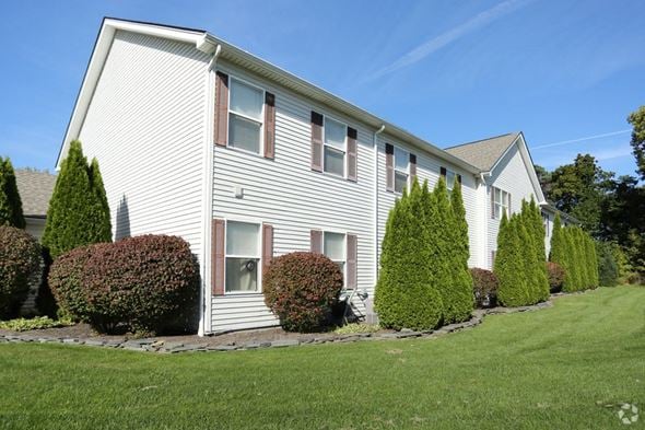 Webster apartment for rent - a white house with trees and bushes in front of it