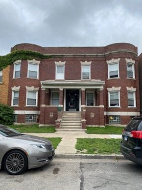 Chicago apartment for rent - a red brick building with cars parked in front of it
