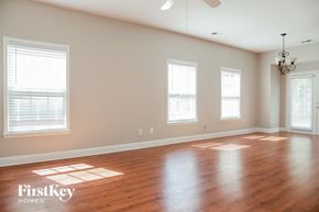 Gastonia house for rent - an empty living room with wood floors and three windows