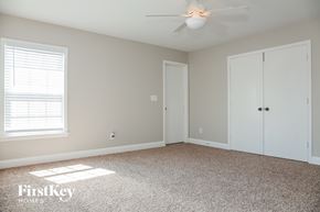 Gastonia house for rent - a bedroom with a carpeted floor and a ceiling fan