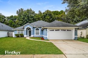 Jacksonville house for rent - a blue house with a white garage door and a lawn