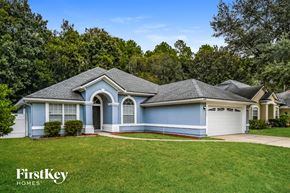 Jacksonville house for rent - a blue house with a gray roof and a grassy yard