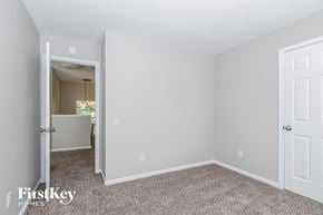 Charlotte house for rent - a bedroom with white walls and carpet and a door to a closet