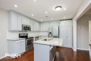 Winder house for rent - a kitchen with white cabinets and a marble counter top