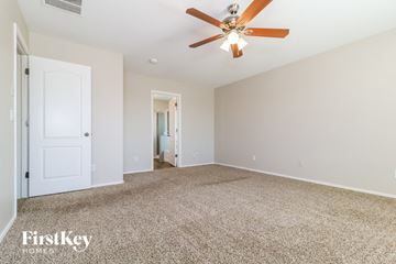 Buckeye house for rent - a spacious living room with carpet and a ceiling fan