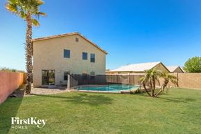 Buckeye house for rent - a backyard with a pool and a house with a palm tree
