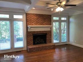 Gastonia house for rent - a living room with a brick fireplace and a ceiling fan