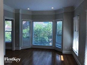 Gastonia house for rent - a living room with large windows and a wood floor