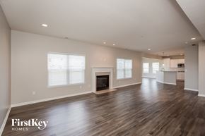 New Palestine house for rent - A spacious living room with wood flooring and a fireplace.