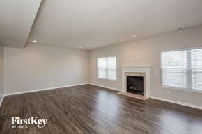 New Palestine house for rent - A spacious room with a fireplace and wooden flooring.