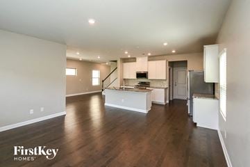 Charlotte house for rent - an open kitchen and living room with wood flooring and white cabinets