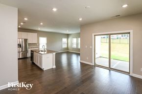 Charlotte house for rent - an empty living room with a kitchen and a sliding glass door