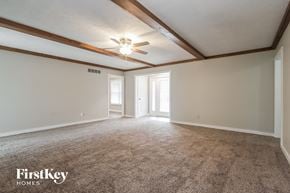 Carmel house for rent - A spacious room with a carpeted floor and a ceiling fan.