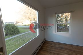 Longview apartment for rent - A room with a window showing a view of a lawn and trees.
