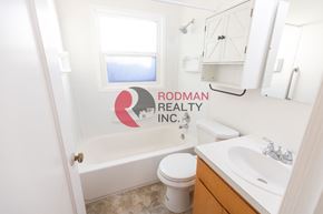 Longview apartment for rent - A bathroom with Rodman Realty Inc. logo on the wall.