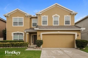 Orlando house for rent - a beige house with a garage door and a lawn