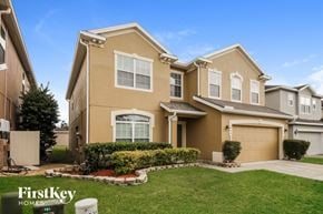 Orlando house for rent - a beige house with a lawn in front of it