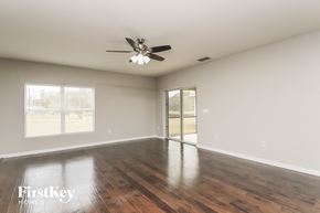 Orlando house for rent - an empty living room with wood floors and a ceiling fan